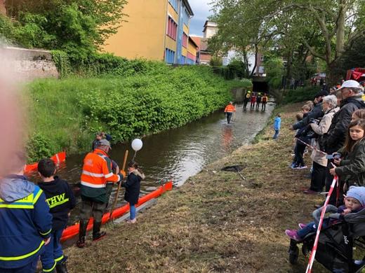 Zuschauerinnen und Zuschauer säumen das Ufer